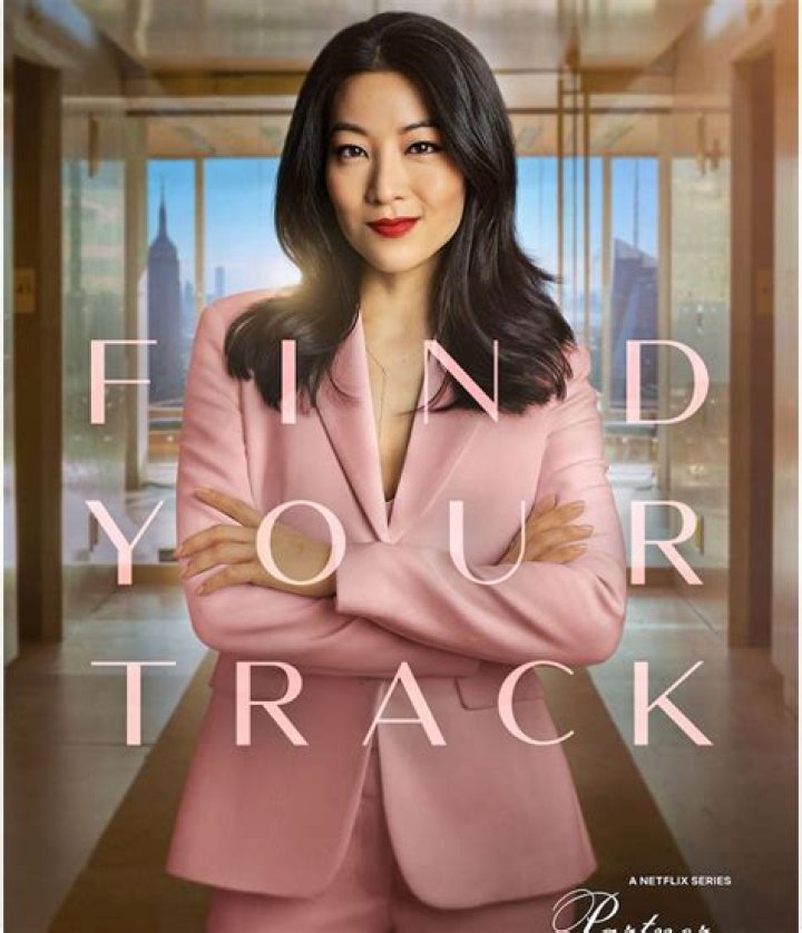 Arden Cho as Ingrid Yun in Netflix series Partner Track episode 1, she is dressed in a pink blazer and sitting at a table Arden Cho as Ingrid Yun in Netflix series Partner Track episode 1, she is dressed in a pink blazer and sitting at a table
